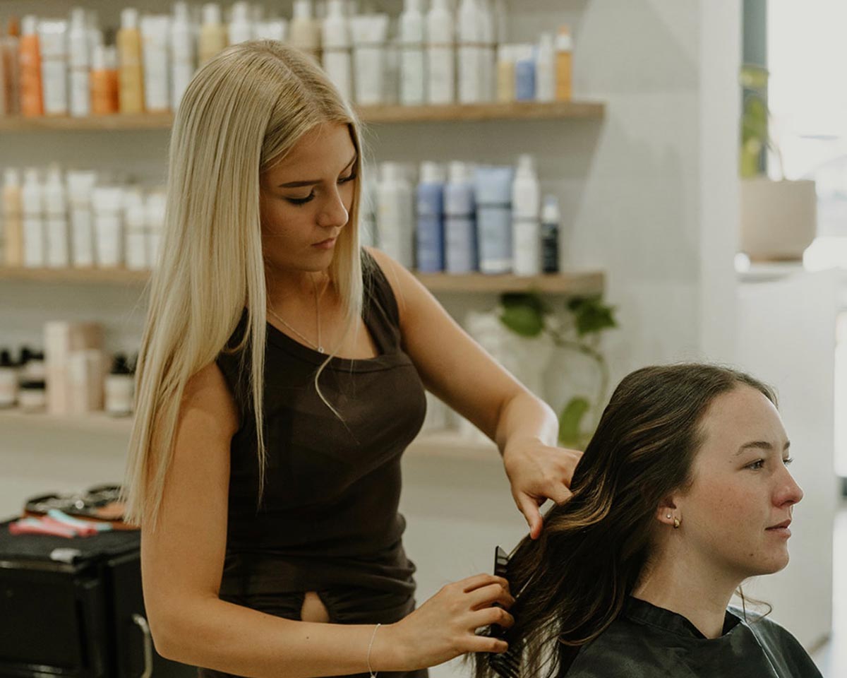Hairdresser styling a client's hair at Calista Hair & Co