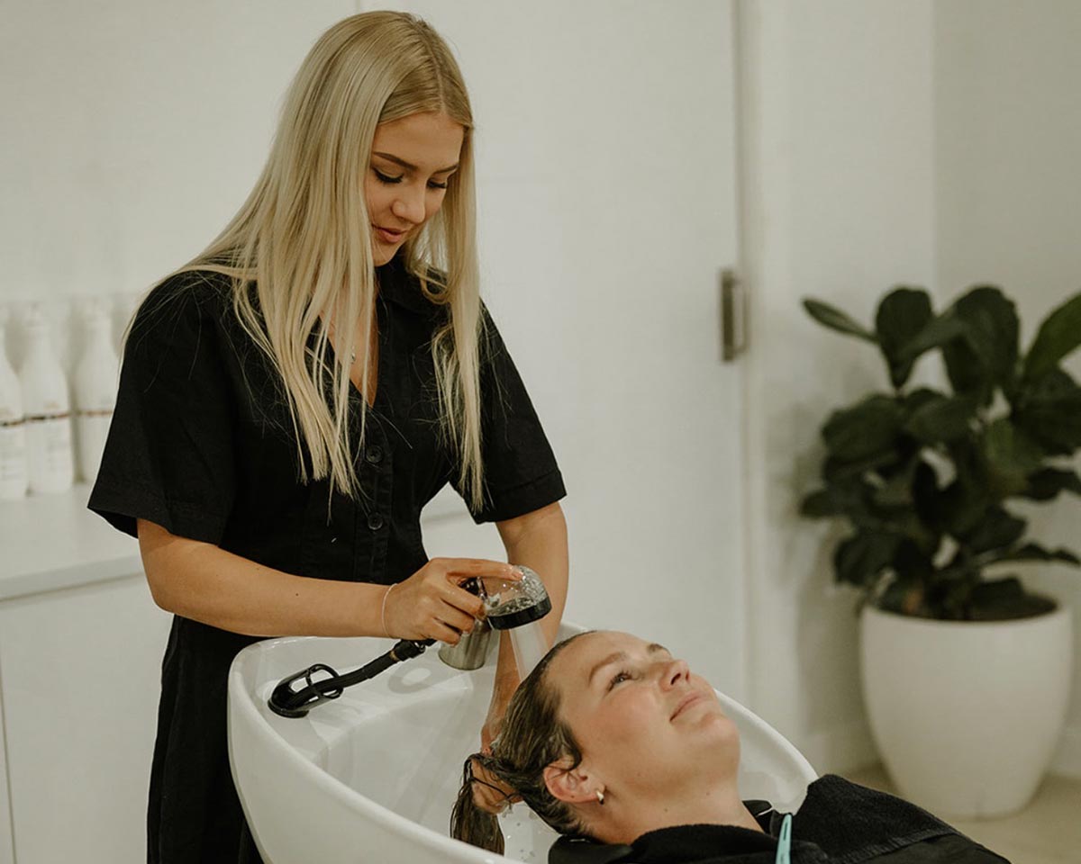 Client enjoying a professional hair wash at Calista Hair & Co